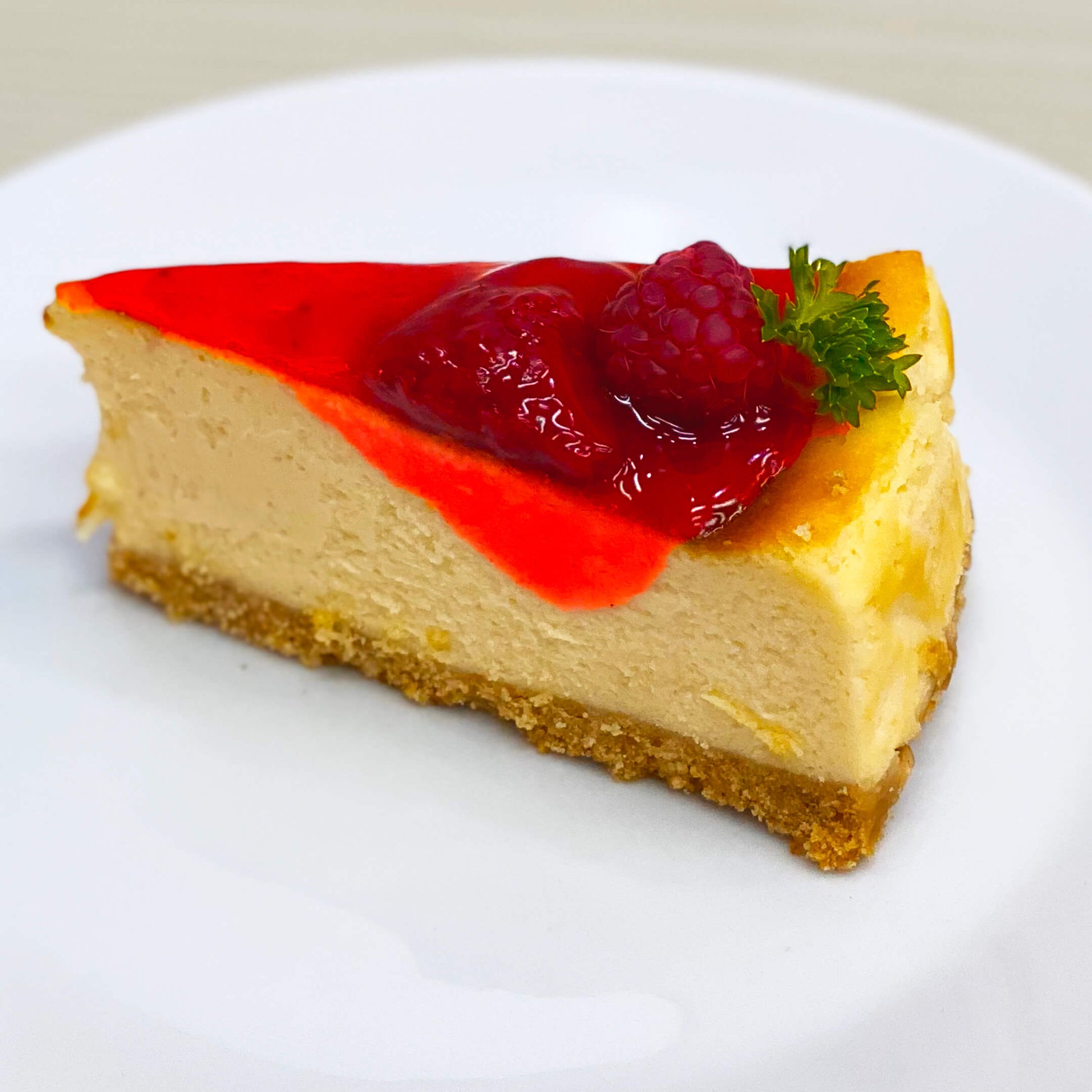 ชีสเค้กราสป์เบอร์รี่จากร้านเบเกอรี่ Yummy Yim ในพัทยา ชิ้นหนึ่งราดด้วยซอสราสป์เบอร์รี่สด